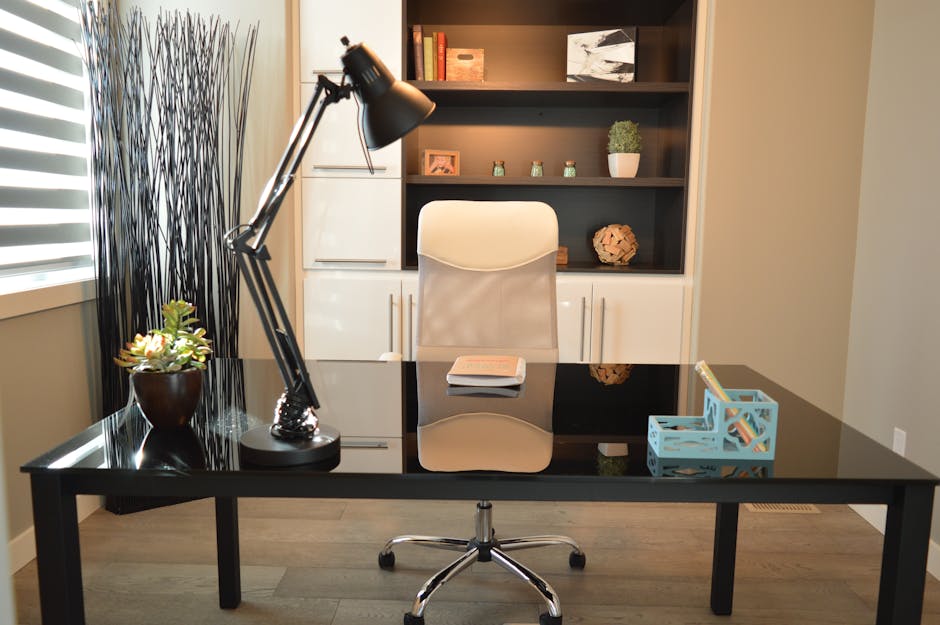 Stylish modern office workspace featuring a black desk, lamp, and white chair with shelving